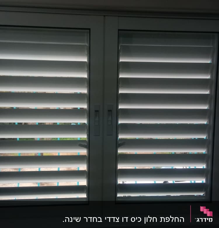 תריסי אלומיניום לבנים בחלון זכוכית כפול